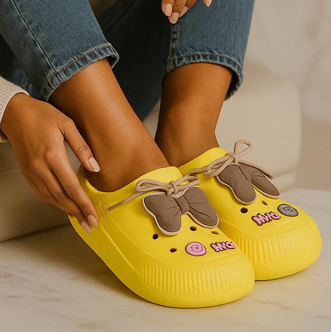 Yellow clogs with decorative elements on a neutral background
