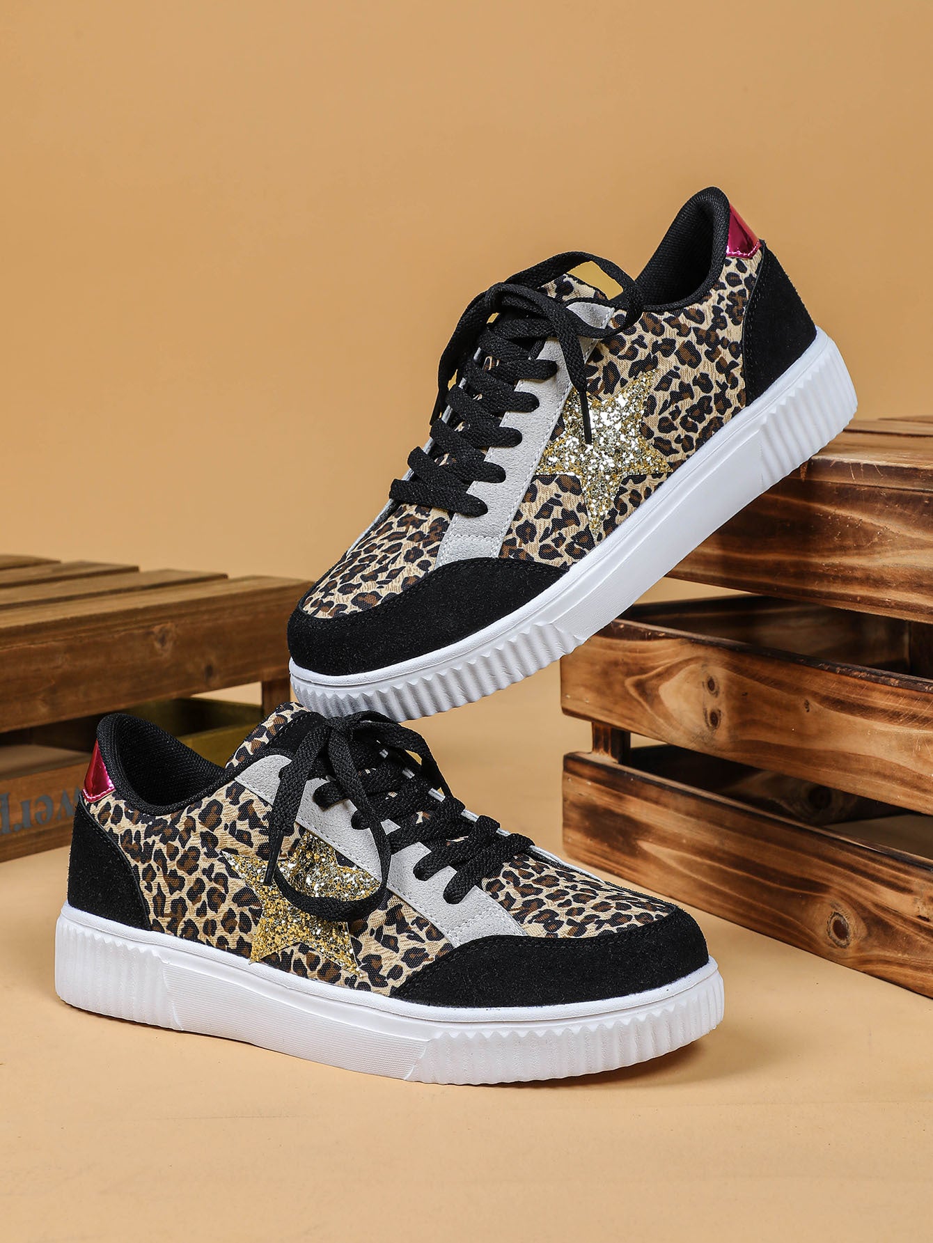 Leopard print sneakers with black and white accents on a wooden surface.