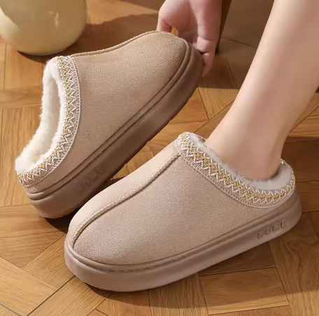 Beige slippers with white sole on a wooden floor